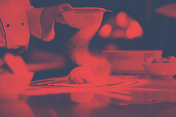 Image showing chef sprinkling flour over fresh pizza dough