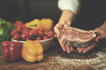 Image showing Chef holding juicy slice of raw steak