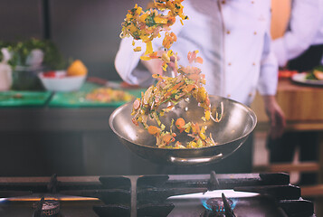 Image showing chef flipping vegetables in wok