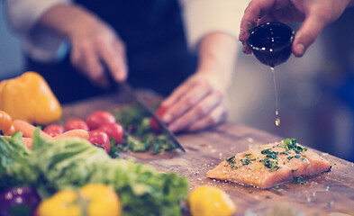 Image showing Chef hands preparing marinated Salmon fish