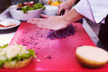 Image showing chef hands cutting salad for burger