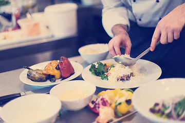 Image showing Chef hands serving vegetable risotto