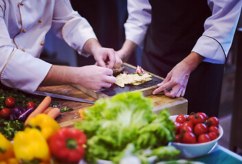 Image showing team cooks and chefs preparing meal