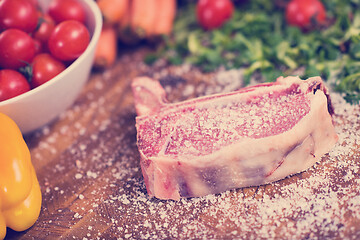 Image showing Juicy slice of raw steak on wooden table