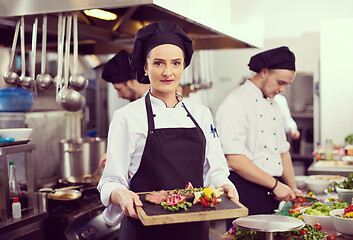 Image showing female Chef holding beef steak plate