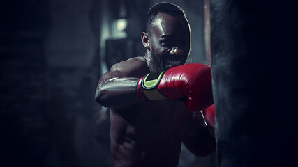 Image showing Hand of boxer over black background. Strength, attack and motion concept