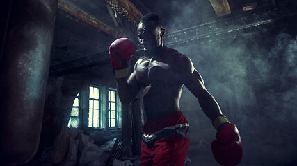 Image showing Hand of boxer over black background. Strength, attack and motion concept