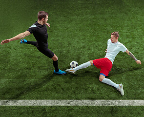 Image showing Football players tackling ball over green grass background