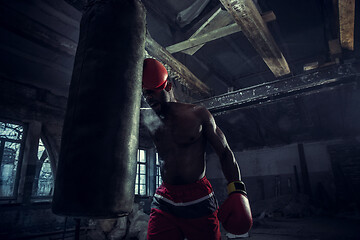 Image showing Hand of boxer over black background. Strength, attack and motion concept