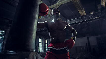 Image showing Hand of boxer over black background. Strength, attack and motion concept