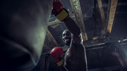 Image showing Hand of boxer over black background. Strength, attack and motion concept