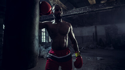 Image showing Hand of boxer over black background. Strength, attack and motion concept