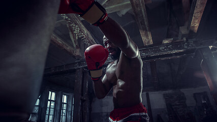 Image showing Hand of boxer over black background. Strength, attack and motion concept