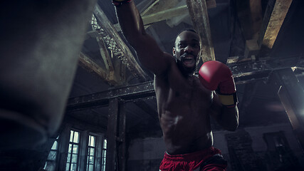 Image showing Hand of boxer over black background. Strength, attack and motion concept