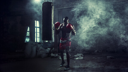 Image showing Hand of boxer over black background. Strength, attack and motion concept