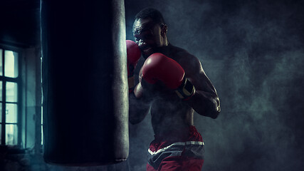 Image showing Hand of boxer over black background. Strength, attack and motion concept