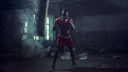 Image showing Hand of boxer over black background. Strength, attack and motion concept