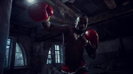 Image showing Hand of boxer over black background. Strength, attack and motion concept