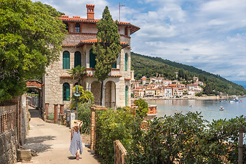 Image showing Female tourist walking along Adriatic sea coast relaxing on vacation in Moscenicka Draga, Istria, Croatia.