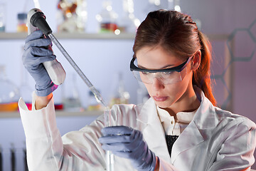 Image showing Young scientist pipetting in life science laboratory.