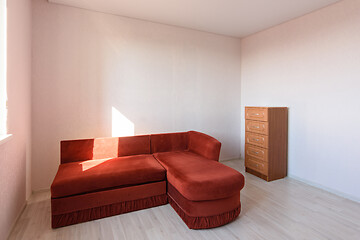 Image showing The interior of a room that was empty before the move, there is a sofa and a chest of drawers in the room