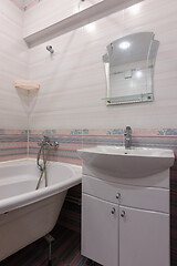 Image showing A fragment of the interior of a conventional bathroom with a washbasin and an acrylic bathtub