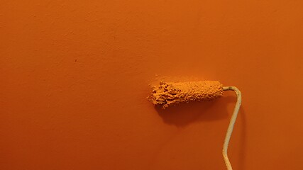 Image showing A paint roller against the wall