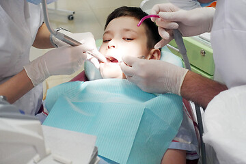 Image showing Dentist examining boy mouth