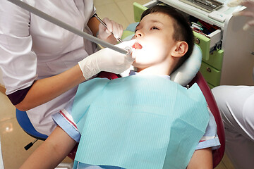 Image showing Dentist examining boy mouth