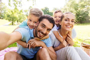 Image showing family having picnic and taking selfie at park