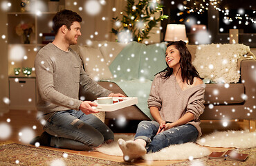 Image showing happy couple with food on tray at home