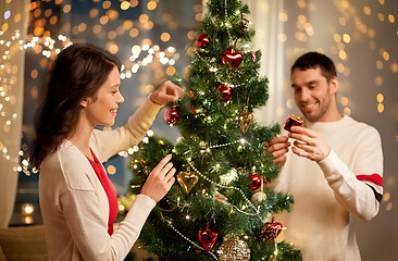 Image showing happy couple decorating christmas tree at home