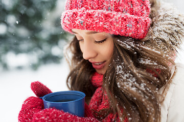 Image showing happy young woman with tea cup in winter park