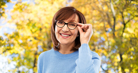 Image showing portrait of old woman in glasses over autumn park