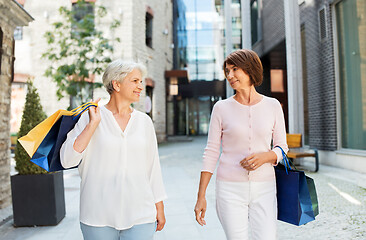 Image showing senior women with shopping bags walking in city