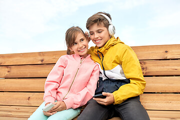 Image showing bou and girl with headphones listening to music