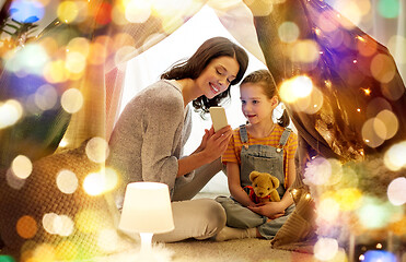 Image showing happy family with smartphone in kids tent at home