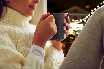 Image showing close up of girl with tea mug sitting at window