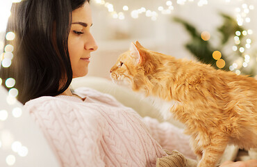 Image showing close up of owner with red cat in bed at home