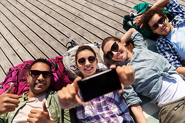 Image showing friends or tourists with backpacks taking selfie