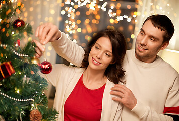 Image showing happy couple decorating christmas tree at home
