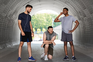 Image showing male friends with earphones training outdoors