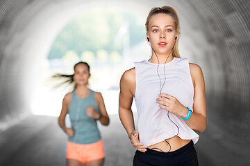 Image showing women or female friends with earphones running