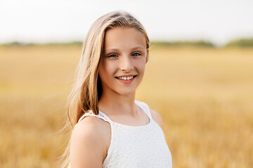 Image showing smiling young girl on cereal field in summer