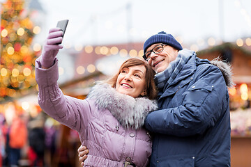 Image showing senior couple taking selfie at christmas market