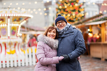 Image showing happy senior couple hugging at christmas market