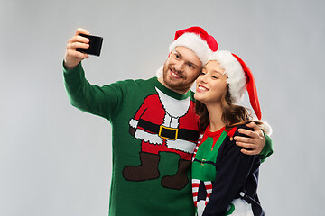 Image showing happy couple in christmas sweaters taking selfie