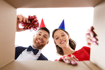 Image showing couple in party hats opening birthday gift box