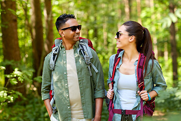 Image showing mixed race couple with backpacks hiking in forest