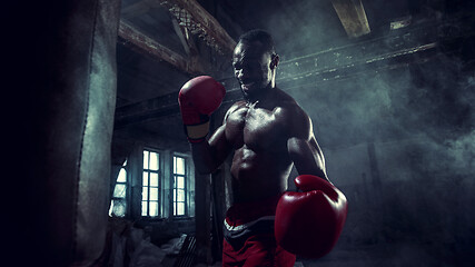 Image showing Hand of boxer over black background. Strength, attack and motion concept